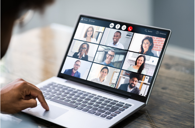 Personne participant à une visioconférence sur ordinateur portable avec plusieurs professionnels pour préparer un événement.