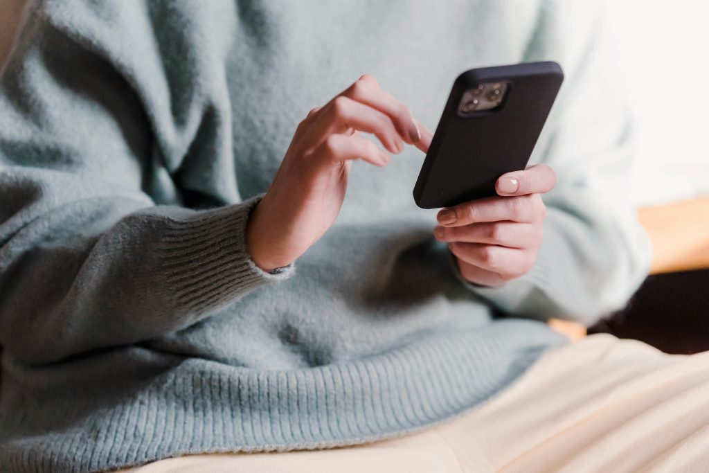 Personne utilisant un smartphone, illustrant la réservation en ligne et la dématérialisation des billets pour un événement.