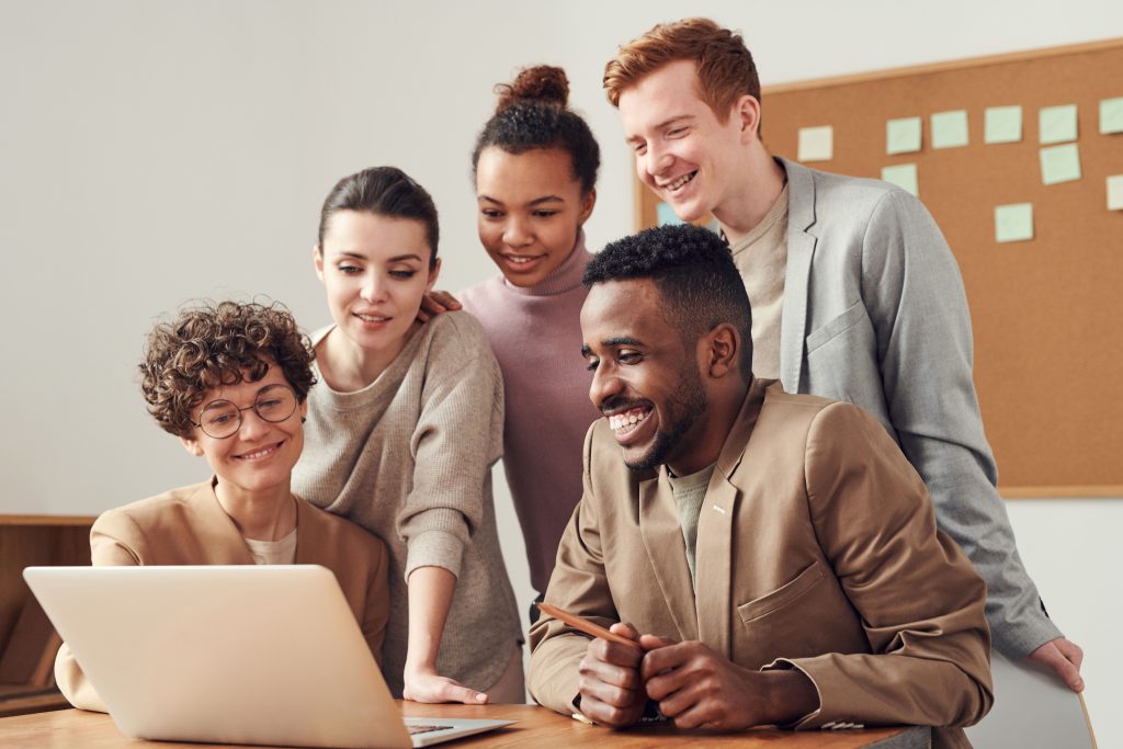 Collègue réunis autour d'un ordinateur portable dans un bureau